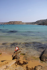 Fototapeta na wymiar Roadsign on a Maltese beach