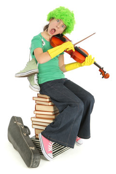 Enfant joue du violon sur une pile de livre