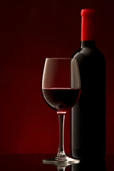 bottle with red wine and glass and grapes