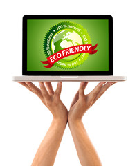 Hand holding laptop with eco friendly sign