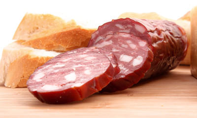 Sausage and bread on wooden surface