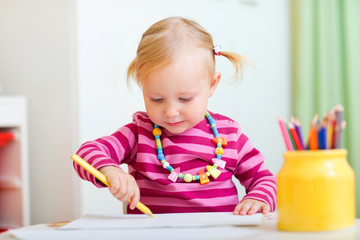 Toddler girl drawing with pencils