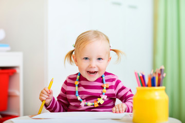 Toddler girl drawing with pencils