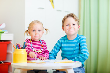 Two kids drawing with coloring pencils