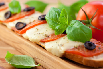 Baked baguette with mozzarella and tomatoes