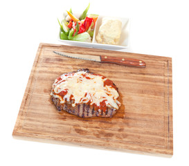 Meat steak garnished with cheese and sauce