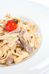 Chicken fettuccine  garnished with cherry