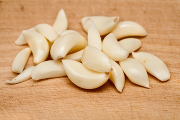 Raw garlic on a wooden plate