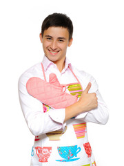 Young smiling man in apron preparing to cook romantic dinner