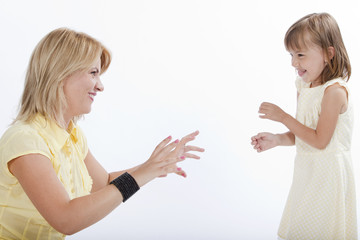 Young beautiful mother playing with her 5 years old daughter