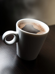 White cup with steaming coffee.