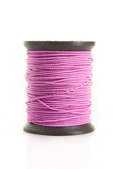 Pink bobbin of thread isolated on white