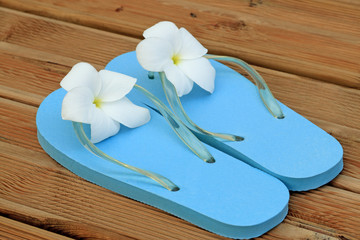 sandales bleues fleuries sur planches terrasse de sauna