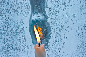 melted frost pattern on window glass and candle