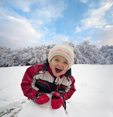 Happy little kid is playing in snow, good winter weather