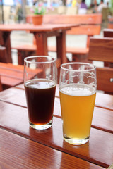 Two glasses of beer on wooden desk