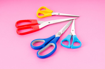 Colorful scissors on the color paper background