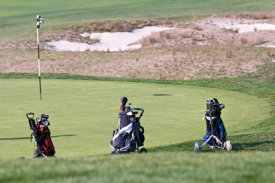 golfbags on a golf course near hole