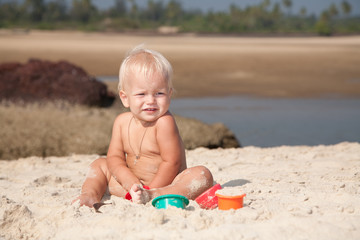 baby plaing on the sea coast