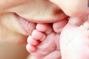 Mother kissing her little newborn baby's feet © philipus