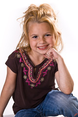 Adorable little girl with blond hair, chin on her hand.