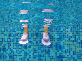 Underwater kis's legs in swimming pool