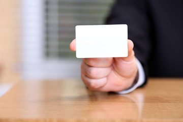 Closeup of business man holding a blank business card