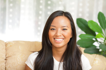 Young happy woman sitting in the living room smiling