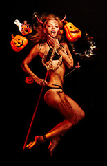 Beautiful devil with trident and Halloween accessories on black