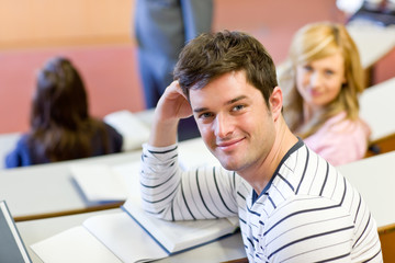 Joyful male student smiling at the camera during a lecture