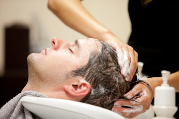 Obraz na płótnie Canvas Przystojny mężczyzna szamponem przez swojego fryzjera
