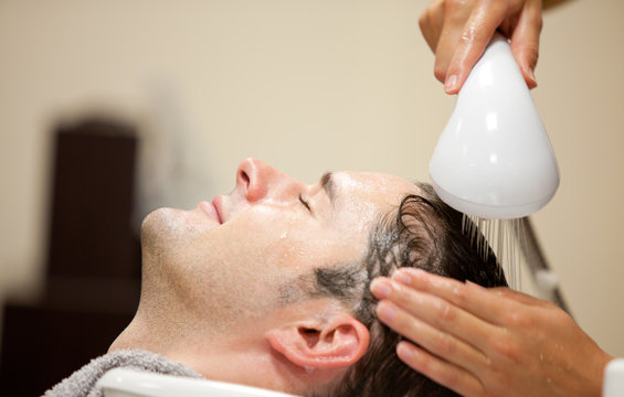 Close-up Of A Young Man Having His Hair Washed In Barbershop