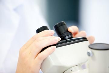 Obraz na płótnie Canvas Close-up kobiet naukowiec patrząc przez mikroskop