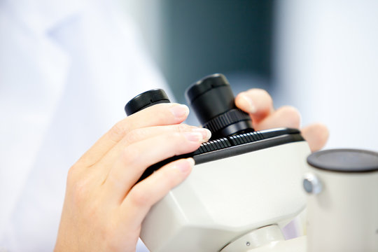 Close-up of a female scientist looking through a microscope