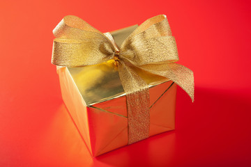 golden gift box over red background