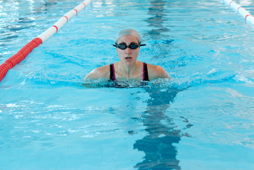 young woman swim on indoor pool. breastroke style.