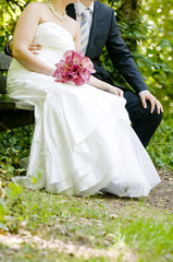 Closeup of bride and groom sitting in a park