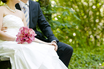 Closeup of bride and groom sitting in a park