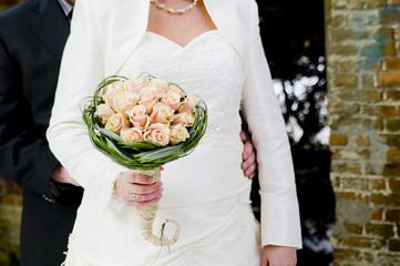 Bride and groom showing wedding bouquet