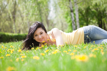Naklejka na ściany i meble Cute woman in the park with dandelions