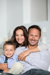 Closeup of parents and child relaxing at home on sofa