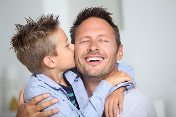 Little bond boy giving a kiss to his dad