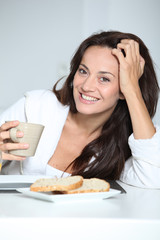 Obraz na płótnie Canvas Beautiful woman having breakfast at home