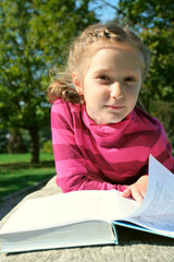 child girl reading at the park