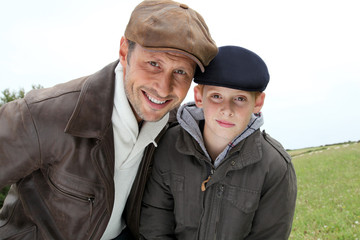 Father and son wearing cap
