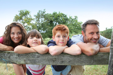 Family leaning on a fence