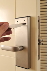 A hand inserting keycard in the electronic lock.