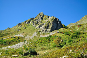 The magnificent mountain range against the blue sky and trees
