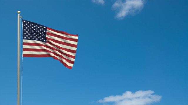 Flag of the USA waving in the wind in front of blue sky