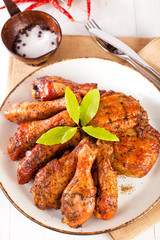 homemade smoked  chicken drumsticks and thighs on a plate